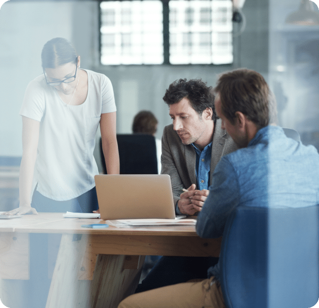 Shot of a group of colleagues talking together over a laptop in an office